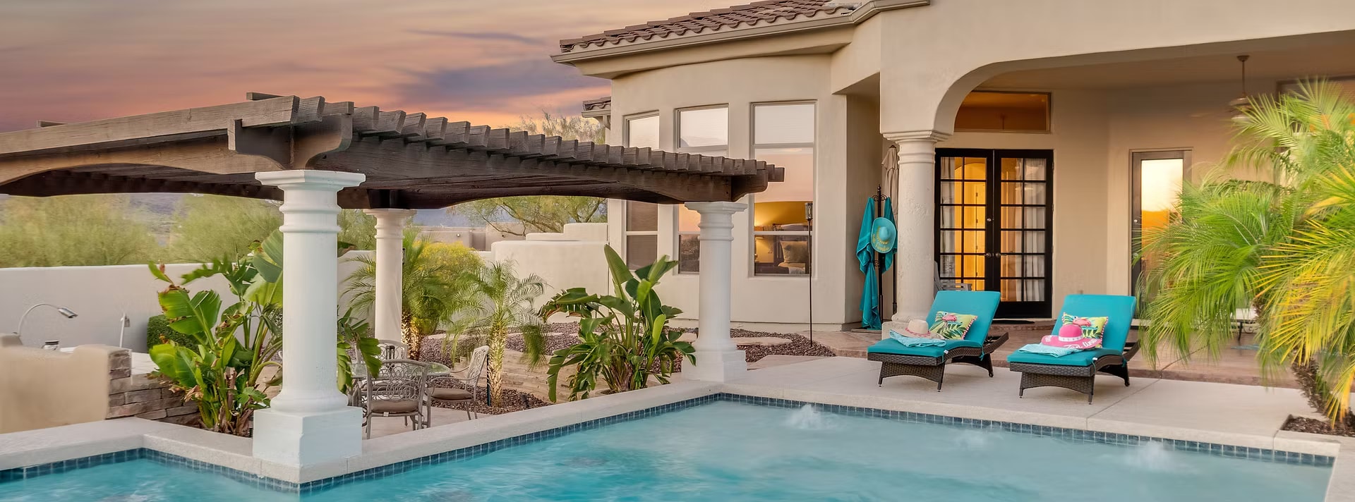 Luxury pool and patio at sunset with pergola
